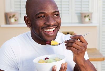Man eating a salad, representing best foods for oral health