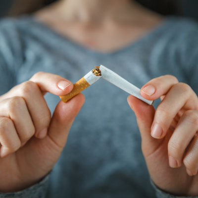 Person snapping a cigarette in two, representing how smoking affects oral health