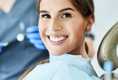 Woman smiling while at the dentist, representing smile club dental membership program