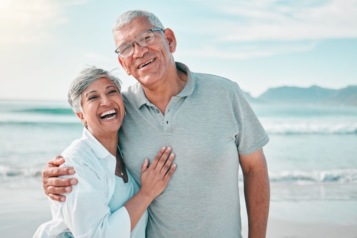 Expert-dental-care-center-near-north-raleigh Happy senior couple embracing on the beach, representing trust and top-rated expert family dentistry at the dental care center north raleigh