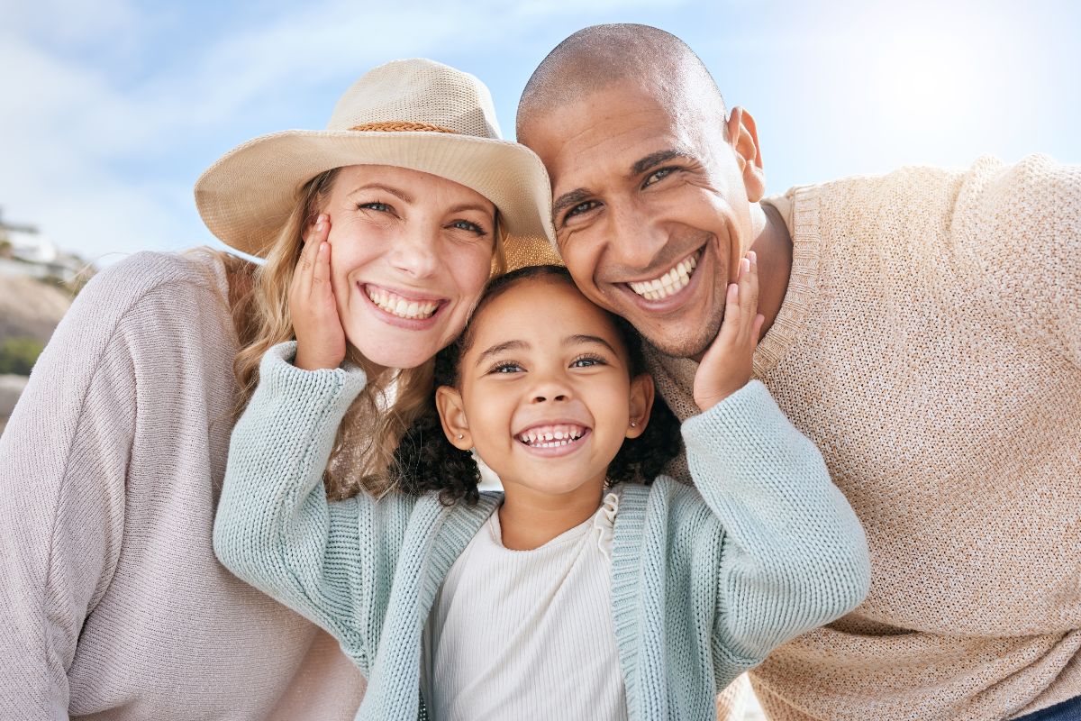 Expert-dental-care-center-near-wendell-falls Smiling family enjoying time together outdoors, representing trusted, top-rated family dentistry near wendell falls