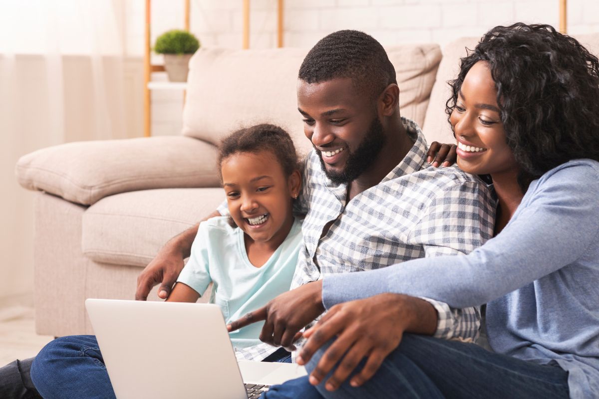 The-dental-care-center-frequently-asked-questions-north-carolina Mom, dad, and daughter sitting at home reviewing expert, top-rated dental care faqs on a computer