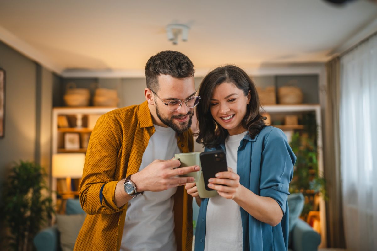 The-dental-care-center-patient-information-north-carolina Male and female patient reviewing expert dental care information and financing options on a phone at home in north carolina