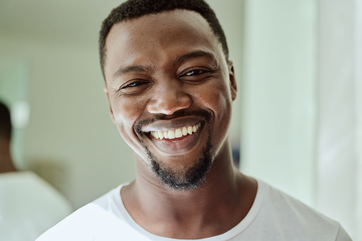 Male patient smiling at the camera while leaving a positive review for expert, top-rated dental care