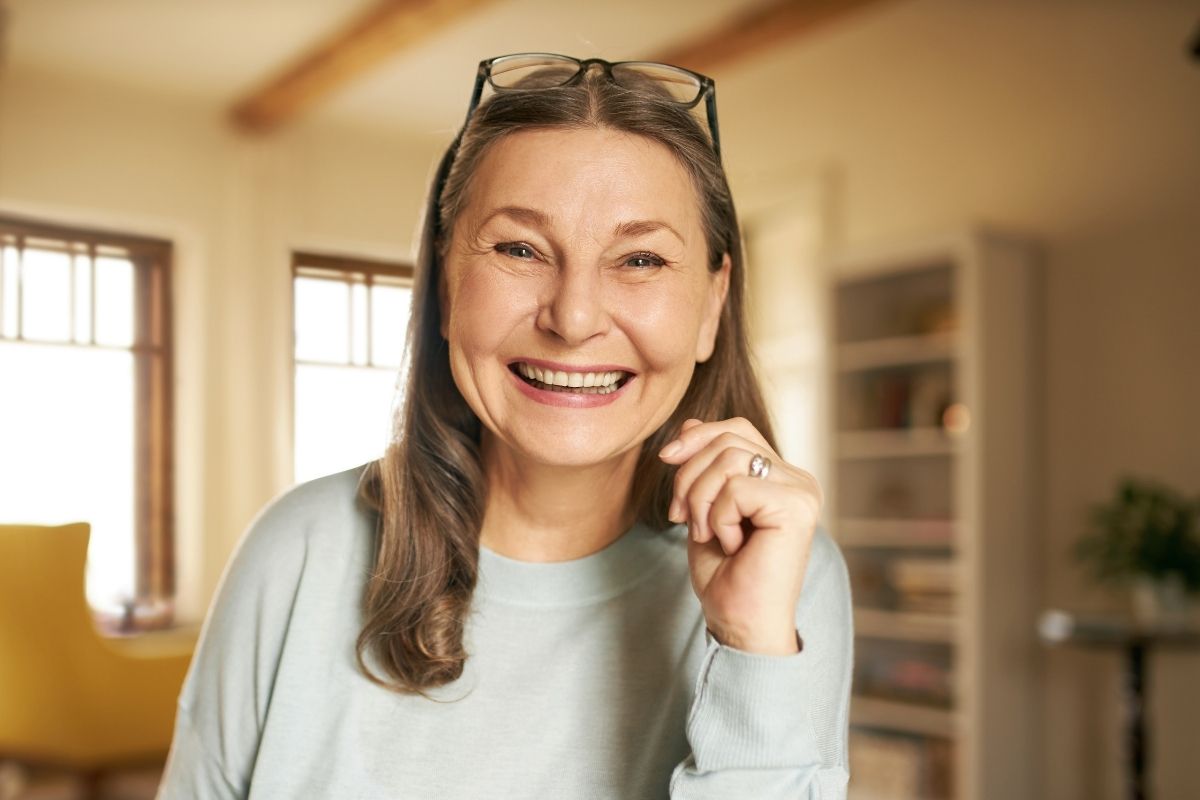 Top-rated-custom-replacement-dentures-north-carolina Happy senior woman smiling indoors with custom replacement dentures in north carolina