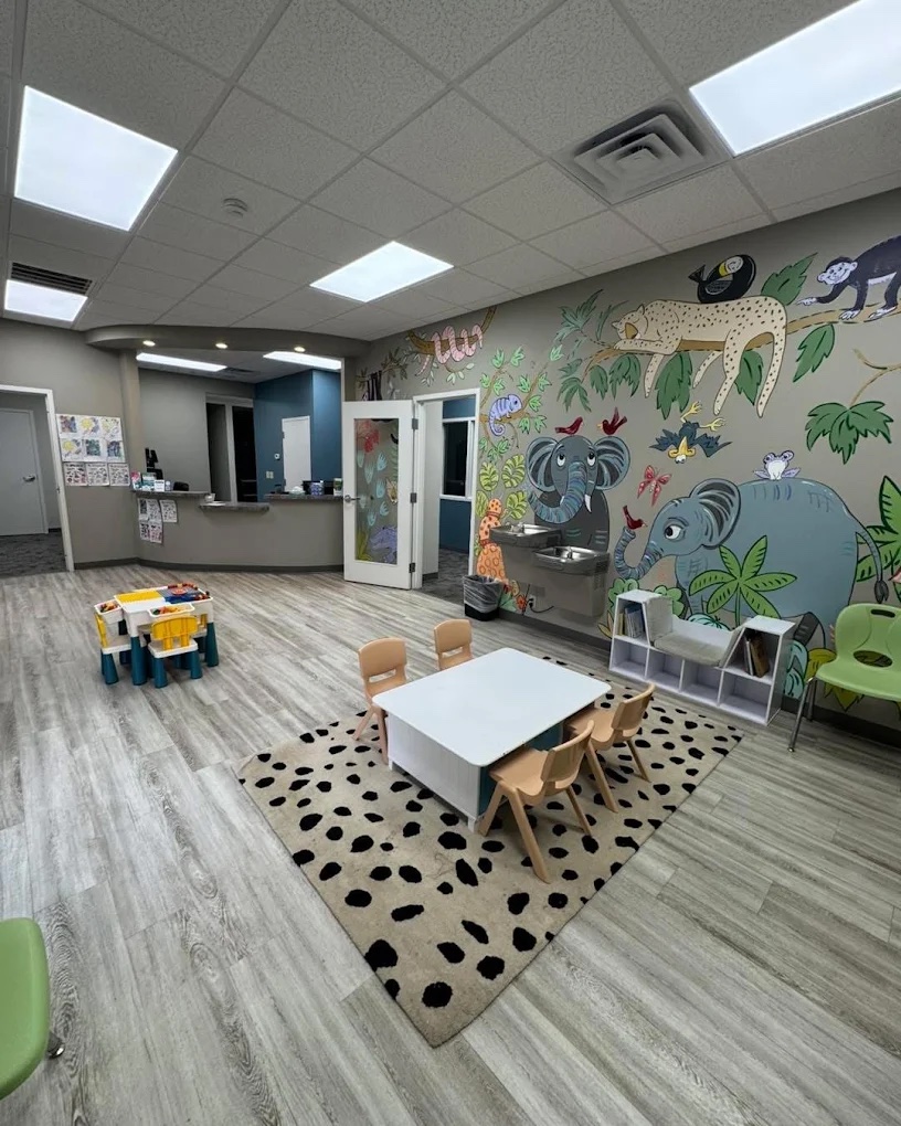 Top-rated-dental-care-eastern-north-carolina-waiting-area Kid-friendly dental waiting area at the dental care center in eastern north carolina with play tables and colorful animal mural