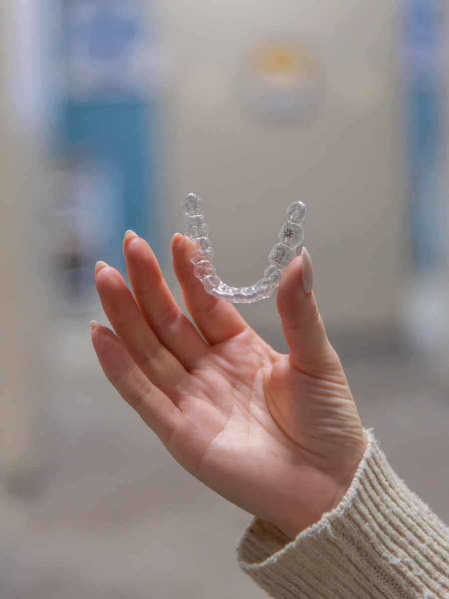The-dental-care-center-smithfield-office-invisalign Clear aligner invisalign tray held in hand in smithfield nc dental office for orthodontic treatment
